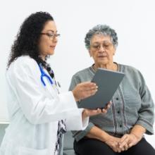Female doctor reviewing chart with senior female patient