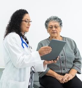 Female doctor reviewing chart with senior female patient