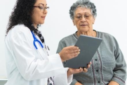 Female doctor reviewing chart with senior female patient
